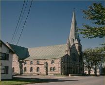 Corner view of St. Paul's United Church, showing the steeply pitched roofs and the corner tower with its tall spire, 1993.; Parks Canada Agency / Agency Parcs Canada, 1993.