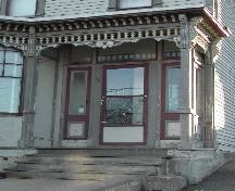 This image provides a view of the highly ornate verandah, the transom window and sidelights surrounding the entry, 2006; City of Saint John