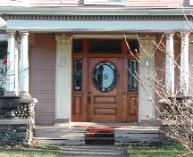 This image provides a view of the entrance flanked by Corinthian pilasters and consisting of a stained glass transom window, sidelights and a wooden door with a rounded, glass panel, 2006
; City of Saint John