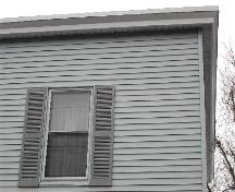 This photograph shows one of the upper storey windows and the eaves, 2005; City of Saint John