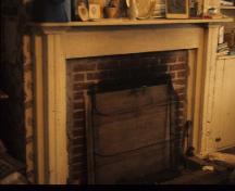 Photographie intérieure de la maison Belmont / maison R.Wilmot, montrant l'habillage en bois du foyer décoré de moulures d'inspiration néo-classique, 1975.; Canadian Inventory of Historic Buildings/ Inventaire des bâtiments historiques du Canada, ca.1975