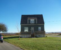 This image shows the front view of the residence with the bay in the background; Town of Shippagan