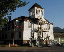 Front view of the Kaslo Municipal Hall, showing the two-storey front portico and staircases, and the belfry, 2003.; Parks Canada Agency / Agence Parcs Canada, 2003.