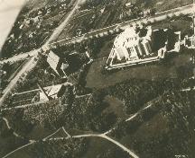 Aerial view of the Temple of the Church of Jesus Christ of Latter Day Saints, showings its siting in the midst of a landscaped square with a surrounding stone wall separating it from the surrounding town, 1926.; Department of Energy, Mines and Resources / Ministère de l'Énergie, des Mines et des Ressources, 1926.