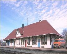General view of the Biggar Railway Station, showing the low, rectangular, horizontal one-and-a-half-storey massing, 1990.; Parks Canada Agency / Agence Parcs Canada, 1990.