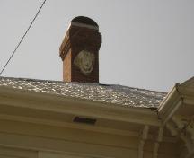 This photograph shows the carved face on the chimney, 2008; Town of St. Andrews