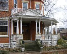 Of note are the front entrance and porch with upper balcony.; Kayla Jonas, 2008.