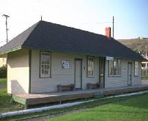 General view of the Carbonear Railway Station, showing its modest scale, simple design, hip roof; overhanging eaves, and wood-frame construction.; Parks Canada Agency / Agence Parcs Canada.