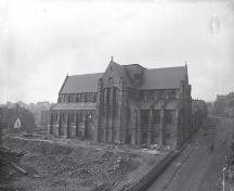 View of the Anglican Cathedral from Cathedral Street, with a view of a corner of the Gower Street Methodist Church on the left, and the old wooden chapel, pre-1892.; Centre for Newfoundland Studies photo 2.02.003