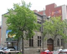 Vue générale du manège militaire, qui montre la façade principale symétrique en pierre calcaire de Montréal, rustiquée et texturée, de couleur grise, 2006.; R. Goodspeed, 2006.