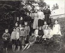 Class photo of students circa 1910 in front of the old school house, Cape George, NS. 

; Courtesy of the Antigonish Heritage Museum