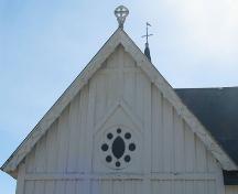 This image presents the cross motif displayed in the woodwork of the west gable.; PNB 2005