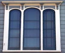 Cette image montre la fenêtre tripartite au milieu de la baie centrale de la façade arrière dont le verre est gravé de motifs floraux victoriens.; City of Saint John