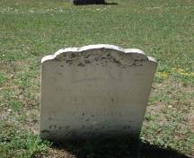 Featured is a headstone with inscription of an early settler interred at the cemetery.; Kendra Green, 2007.