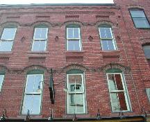 This photograph shows the roofline, window detail, and the decorative brick design, 2004; City of Saint John