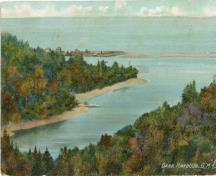 This image is an old colored postcard showing Dark Harbour Pond from the eastern shore looking west. The steep cliffs and the pond with its seawall are visible. ; Grand Manan Archives