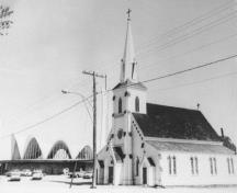 Image de la nouvelle église à côté de l’ancienne avant sa démolition. Cette dernière avait été construite en 1864.; Private collection