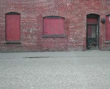 This photograph shows the entranceway and windows under flush segmented arches, 2004.; City of Saint John