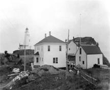 This historic image shows the Swallowtail Light Keeper's House, constructed in 1958, with its outbuildings and a boathouse. ; Laurie Murison