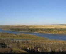 View of island on far side of river (fur trade remains are in stand of tall, dark spruce trees), 2004.; Government of Saskatchewan, Marvin Thomas, 2004