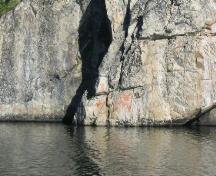 View of ochre-coloured pictographs on rock face, 2004.; Government of Saskatchewan, Erin Ermel, 2004.