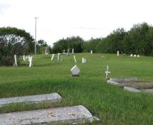 View of cemetery, with commemorative cairn in background, 2009.; Ross Herrington, 2009.