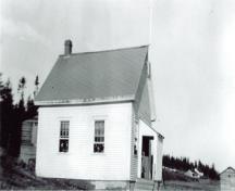 Image of the Deep Cove School taken around 1943 with children hanging out the windows.; Grand Manan Archives P8 photo collection