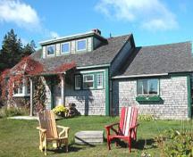 Cette image montre la maison principale des chalets Whale Cove où une salle à manger saisonnière est exploitée.; Whale Cove Cottages