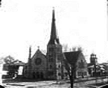 The Auld Kirk, with its bell tower, stands on York Street after being moved in 1882 to make room for the new St. Paul's Presbyterian Church. The Auld Kirk is considerably smaller than the new church.  ; Provincial Archives of New Brunswick, George T. Taylor Collection, P5-307