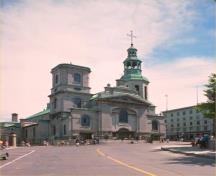 Vue générale de la Cathédrale-Catholique-Notre-Dame, montrant la façade néoclassique richement décorée et flanquée de deux tours d'époque et de style différents.; Parks Canada Agency/Agence Parcs Canada