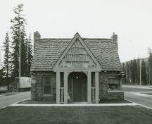 Façade of Building 2, showing the front porch, the gable end of which frames the words “Banff National Park”, which protects the main entrance, 1985.; Parks Canada Agency / Agence Parcs Canada, 1985.