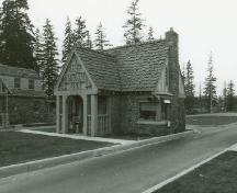 Side view of Building 2, showing the cedar shingles laid in staggered lines, the half-timbering of the upper portion of the building and the use of locally quarried split fieldstone in irregular courses for the exterior walls, 1985.; Parks Canada Agency / Agence Parcs Canada, 1985.