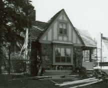 Façade of Building 3, showing the half-timbering featured on the upper half of the building and the use of locally quarried split fieldstone in irregular courses for the exterior walls, 1985.; Parks Canada Agency / Agence Parcs Canada, 1985.