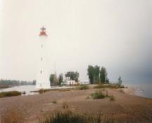 Vue générale du phare, qui montre l’extérieur peint en blanc et la lanterne peinte en rouge, 1986.; Canadian Coast Guard / Garde côtière canadienne, 1986.