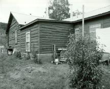 Side elevation of the N.W.M.P Married Officers' Quarters, showing the low-pitch gable roof, 1987.; Parks Canada Agency / Agence Parcs Canada, 1987.
