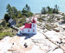 General view of Brebeuf Island Front Range Light Tower, showing its position on a flat bare rock surface.; Parks Canada Agency/ Agence Parcs Canada, Fisheries and Oceans Canada/ Pêches et Océans Canada