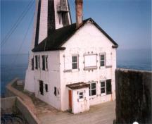 Vue du phare de Gannet Rock, où l'on peut apercevoir ses murs en béton armé, ses volets en bois et l’accès direct au phare depuis chaque étage de la résidence, 1999.; Canadian Coast Guard / Garde côtière canadienne, 1999.