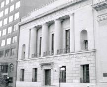 Vue générale du l' Édifice de la Banque de Nouvelle-Écosse, montrant ses quatre colonnes autoportantes et sa corniche, 1985.; Agence Parcs Canada / Parks Canada Agency, 1985.