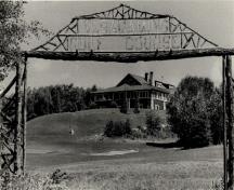 Vue du pavillon de golf (B7), qui montre son emplacement au bord d’un promontoire qui surplombe le terrain de golf.; Agence Parcs Canada / Parks Canada Agency