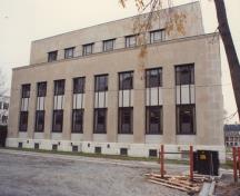 View of the exterior of the Government of Canada Building, showing its vertical ribbon windows with aluminum details, 1991.; Department of Public Works / Ministère des Travaux publics, 1991.