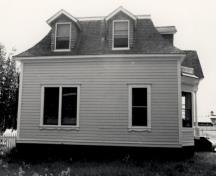 Side view of St. Andrew's Manse, showing the mansard-roofed main structure and the projecting dormers, 1987.; Parks Canada Agency / Agence Parcs Canada, 1987.
