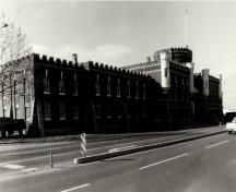 View of the Bay Street Armoury, showing the crenellated parapet walls that crown the building, 1990.; Ministère de la Défense nationale / Department of National Defence, 1990