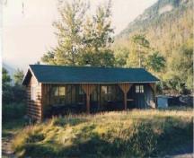 General view of Kitchen Shelter 7, showing the simple, low massing of the one-storey, three-sided structure, 1990.; Parks Canada Agency / Agence Parcs Canada, 1990.