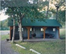 General view of Kitchen Shelter 8, showing the squared timbers used as posts within the open front, 1990.; Parks Canada Agency / Agence Parcs Canada, 1990.