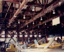 Vue du Hangar 82, qui montre les grands blocs de fenêtres laissant pénétrer beaucoup de lumière à l’intérieur, 1995.; Ministère de la Défense nationale / Department of National Defence, 1995.
