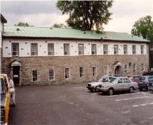 View of Building 1, showing the ground floor’s solid masonry construction and the stucco finish of the upper storey, 1993.; Agence Parcs Canada / Parks Canada Agency, 1993.