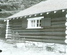 Side elevation of the Bryant Creek Warden Cabin, showing its use of wood construction with round logs laid horizontally, c.1990.; Agence Parcs Canada / Parks Canada Agency, c. 1990.