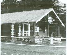Corner view of the Bryant Creek Warden Cabin, showing its three log, tie-beam support system evident in the front porch, c. 1990.; Agence Parcs Canada / Parks Canada Agency, c. 1990.