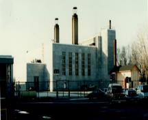 View of the façade of the Heating Plant, showing the exterior treatment which recalls the granite, five bay entry portico of the Bureau, 1993.; Department of Public Works / Ministère des Travaux publics, 1993.