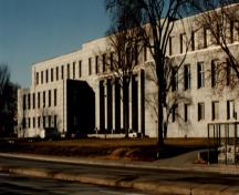View of the main entrance of the National Printing Bureau, showing the building’s monumental and symmetrical composition consisting of stepped, crisply defined, projecting and receding rectilinear volumes, 1993.; Department of Public Works / Ministère des Travaux publics, 1993.